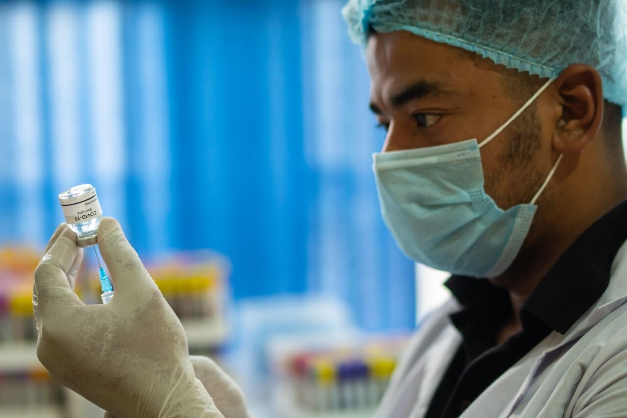 Laboratory scientist examining a vaccine vial